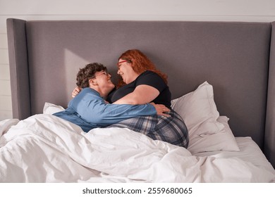 Happy lesbian couple embracing and smiling in bed - Powered by Shutterstock