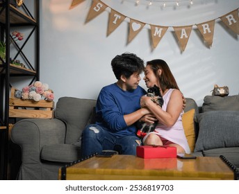 Happy lesbian couple enjoy their just married celebration with chihuahua puppy dog at home. Cheerful Asian LGBTQ gay couple celebrate newlywed in living room. Romantic homosexual people, portrait. - Powered by Shutterstock