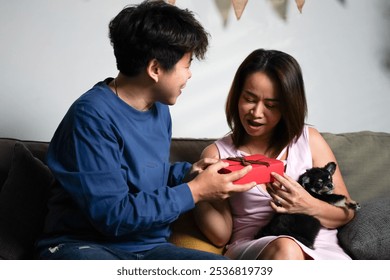 Happy lesbian couple enjoy their just married celebration with chihuahua puppy dog at home. Cheerful Asian LGBTQ gay couple celebrate newlywed in living room. Romantic homosexual people, portrait. - Powered by Shutterstock