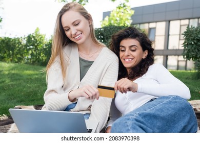 Happy Lesbian Couple Holding Credit Card While Doing Online Shopping During Picnic