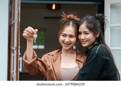 Happy Lesbian Couple Moving into New Home, Embracing LGBT Love and holding keys of new home - Powered by Shutterstock