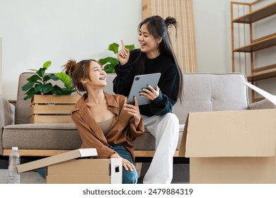 Happy Lesbian Couple Moving into Smart Home, Unpacking Boxes and Using Tablet to Set Up Modern Technology in New House - Powered by Shutterstock