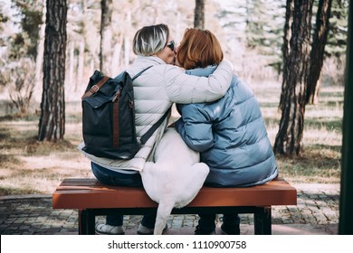 Happy Lesbian Couple Sitting With A Dog