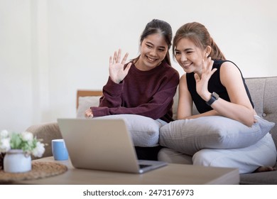 Happy Lesbian Couple Video Call Friends on Laptop at Home. LGBTQ Representation, Modern Technology, and Love - Powered by Shutterstock