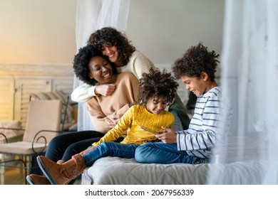 Happy Lesbian Multiethnic Couple In Love With Childen At Home. Family Lgbt Child Happiness Concept