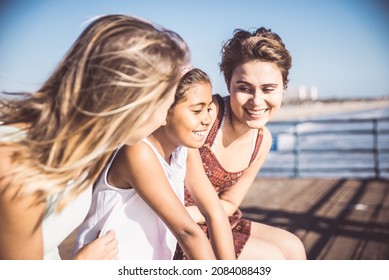 Happy LGBT couple spending time together with their adopted daughter. Cinematic image of a young modern  californian family spending time outdoor in santa monica