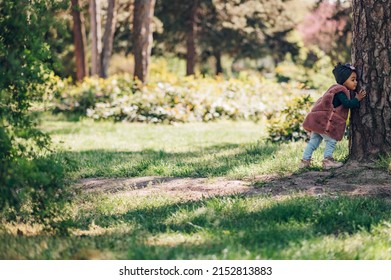 Happy Little African American Baby Girl Walking In A Park. Beautiful Black Little Girl Laughing And Playing Outside. Hugging A Tree. Little Nature Lover.