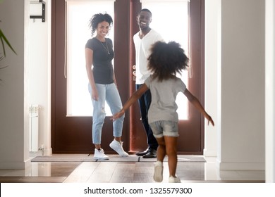 Happy Little African American Girl Running To Father Returning, Going Back Home After Work, Greetings, Daughter With Attractive Smiling Mother In Hall Welcome Back Dad, Family Reunion Concept