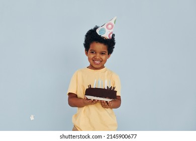 Happy Little African American Kid Have Fun Indoors At Birthday Party Holds Cake.