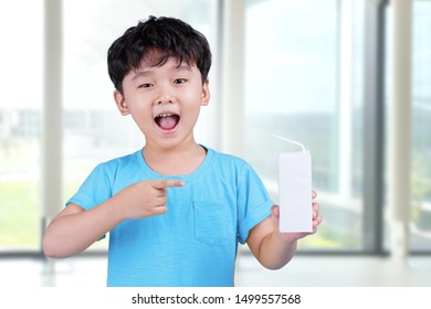 Happy Little Asian Boy Holding Box Of Milk