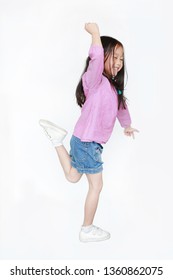 Happy Little Asian Child Girl Jumping In Air On White Background. Full Length Side View Of Smiling Kid Concept.