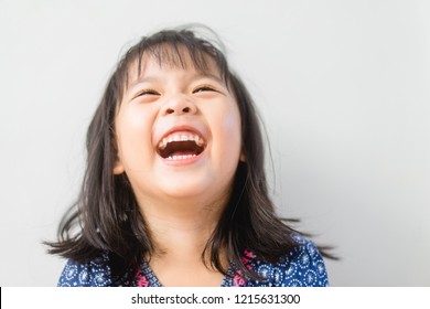 Happy Little Asian Girl Child Showing Front Teeth With Big Smile And Laughing: Healthy Happy Funny Smiling Face Young Adorable Lovely Female Kid.Joyful Portrait Of Asian Elementary School Student.