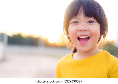 Happy Little asian girl child showing front teeth with big smile and laughing: Healthy happy funny smiling face young adorable lovely female kid.Joyful portrait of asian elementary school student. 