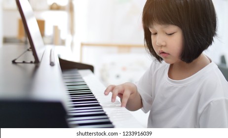 Happy Little Asian Girl Playing Piano