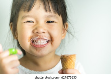 Happy little asian girl thumb up after eat ice cream cone.Portrait of Delicious face funny lovely little girl.