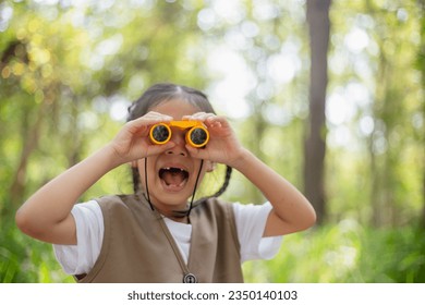 Happy Little Asian girls looking ahead and smiling child with the binoculars in the park. Travel and adventure concept. Freedom, vacation - Powered by Shutterstock