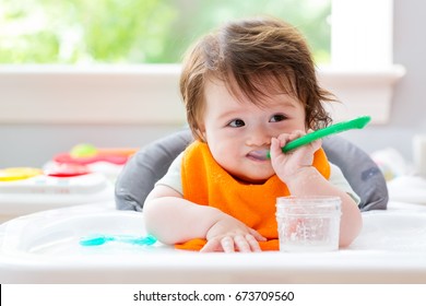 Happy Little Baby Boy Eating Food With A Spoon