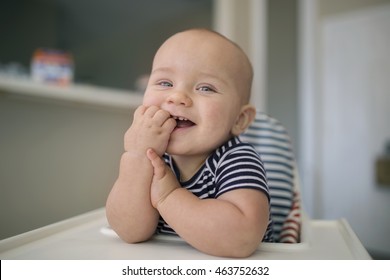 Happy Little Baby Boy Of One Year Old Smiling While Sitting In High Chair At Home