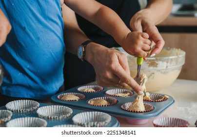 Happy little baby daughter baking muffins at home kitchen with her mother. Happy family. People lifestyle. Food preparation. Sweet food.Happy little baby - Powered by Shutterstock