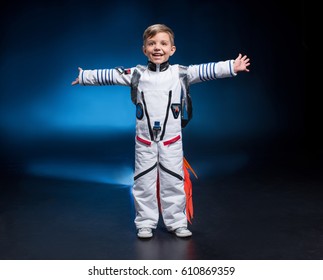 Happy little boy in astronaut costume laughing at camera 