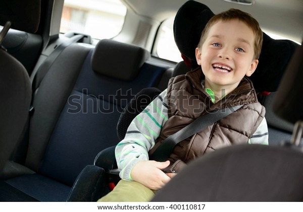Happy little boy in car safety seat. Children car\
safety concept