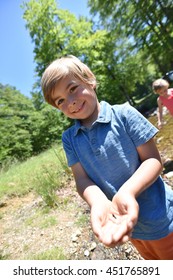 Happy Little Boy Catching Tadpoles In River