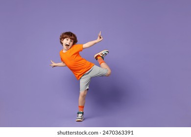 Happy little boy dancing on violet background - Powered by Shutterstock