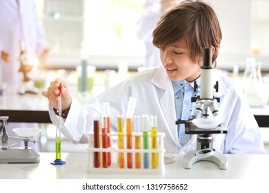 happy little boy making science experiments with microscope (education and scientist concept) - Powered by Shutterstock