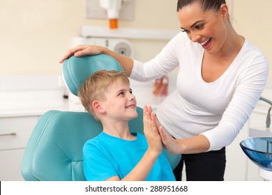 happy little boy and mother high five after dental checkup - Powered by Shutterstock