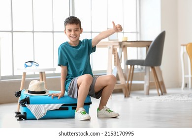 Happy little boy with packed suitcase at home - Shutterstock ID 2153170995