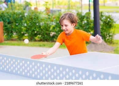 Happy Little Boy Playing Table Tennis Outside