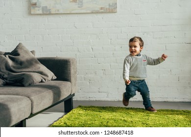 Happy Little Boy Running In Living Room At Home