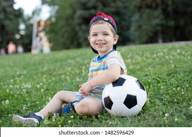 happy little boy sitting on grass hugging ball
 - Powered by Shutterstock