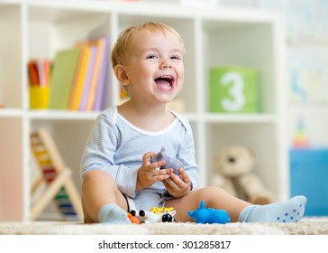 Happy Little Boy. Smiling Child Toddler Plays Animal Toys At Home Or Kindergarten.