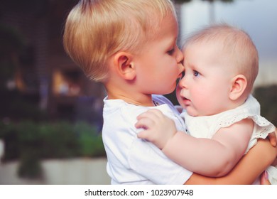 happy little brother playing hugs his sister baby, boy and girl embraces kisses, concept love and parenting. - Powered by Shutterstock