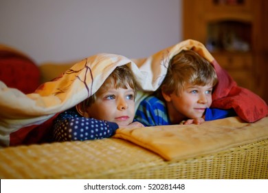 Happy Little Brothers, Adorable Kid Boys Watching Television While Lying. Funny Children Enjoying Cartoons