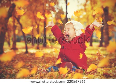 happy little child, baby girl laughing and playing in the autumn on the nature walk outdoors