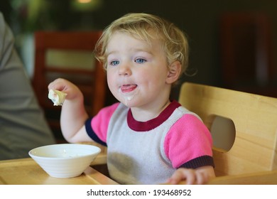 Happy Little Child, Blonde Toddler Girl Eating Tasty Ice Cream From Bowl In Cafe