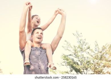 Happy Little Child On Uncle Shoulders Outside In Nature Enjoying Beautiful Day