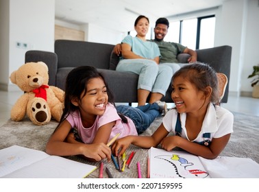 Happy Little Children Drawing With Parents In The Background At Home Living Room. Kids Enjoying Quality Time And Creative Art Together While Man And Woman Babysitting Children In The Living Room