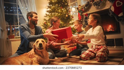 Happy Little Family Exchanging Gifts on Christmas Eve: Brother and Sister Receiving their Gifts. Happy Children Getting New Toys from Mom and Dad, with Family Dog Sharing the Moment - Powered by Shutterstock