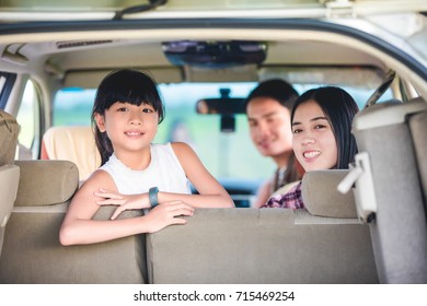 Happy Little Girl  With Asian Family Sitting In The Car For Enjoying Road Trip And Summer Vacation In Camper Van