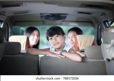 Happy Little Girl  With Asian Family Sitting In The Car For Enjoying Road Trip And Summer Vacation In Camper Van