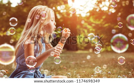 Happy little girl in autumn scenery