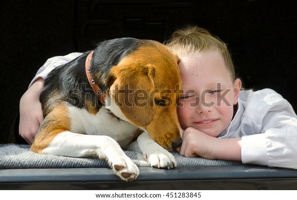 Happy little girl and\
beagle puppy in car
