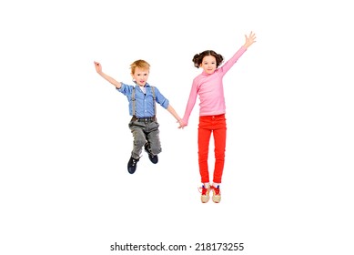 Happy little girl and boy jumping for joy together. Children. Isolated over white. - Shutterstock ID 218173255