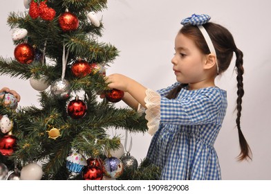 Happy A Little  Girl And Boy Kids Playing Colorful Toy With A Christmas Tree Background.A Dark Skin Kid Have Funny With Family Xmas Morning In Decorated Living Room.Christmas Eve.