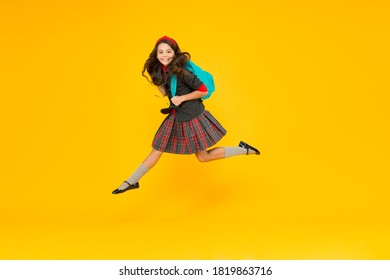 Happy Little Girl Child In Uniform Hurry To School Carrying Backpack In Midair Yellow Background, September 1.