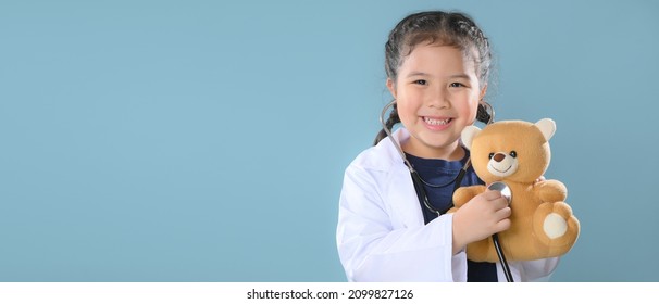 Schönes kleines Mädchen in Arztkittel mit Stethoskop. Kind spielt. Künftiges Berufs- oder Traumjob-Konzept. Fröhlicher Kindertag.