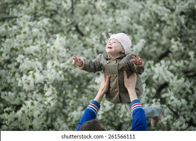 happy little girl with Down syndrome flies up high